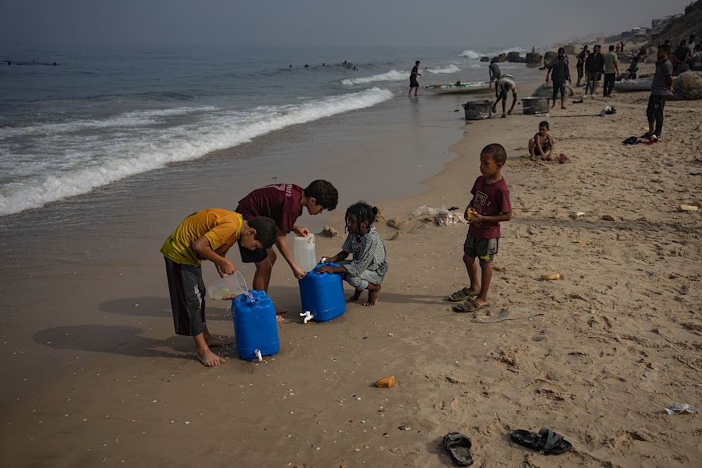 Palestinian children collect seawater at the beach in Deir al Balah, Gaza Strip, Thursday, Nov. 2, 2023. (AP)