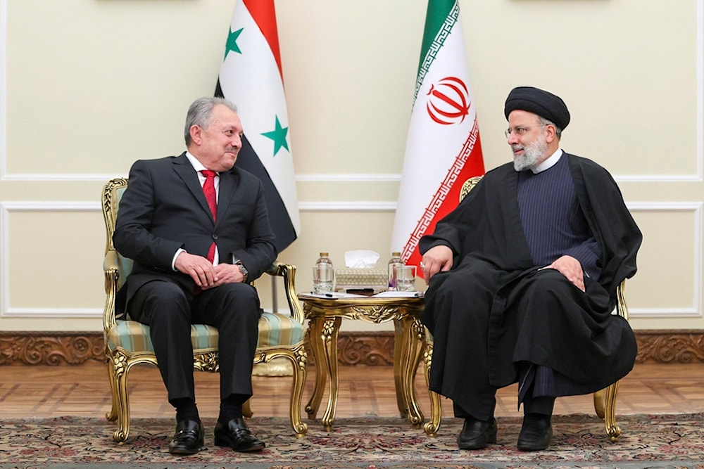 In this photo released by the Iranian Presidency Office, President Ebrahim Raisi, right, meets with Syrian Prime Minister Hussein Arnous at his office in Tehran, Iran, December 9, 2023 (AP)