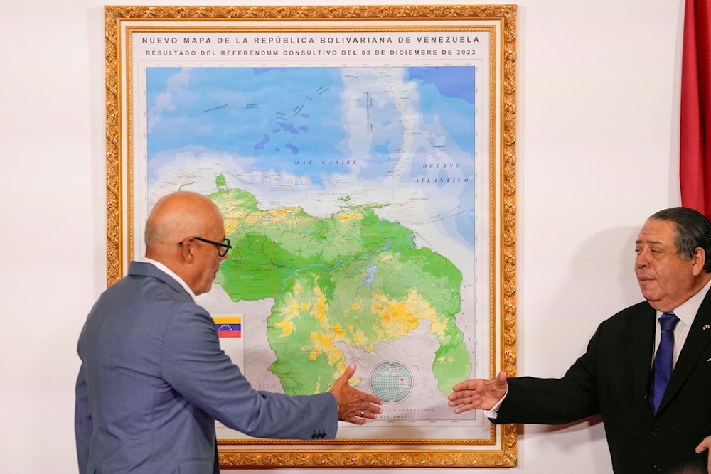 National Assembly President Jorge Rodriguez, left, and Chairman of the Special Commission for the Defense of Guyana Essequibo Hermann Escarra, shake hands after unveiling Venezuela's new map Caracas, Venezuela, Friday, Dec. 8, 2023 (AP)