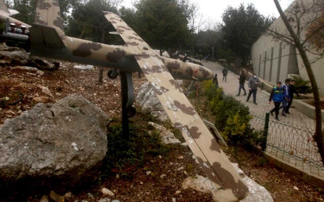 People walk by a replica drone in a war museum operated by Hezbollah in Mlita Village, southern Lebanon, February 19, 2022. (AP)