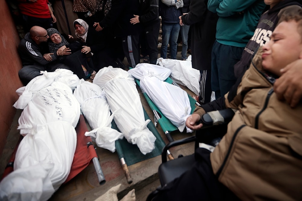 Palestinians mourn relatives killed in the Israeli bombardment of the Gaza Strip outside a morgue in Khan Younis on Sunday, Dec. 10, 2023. (AP)