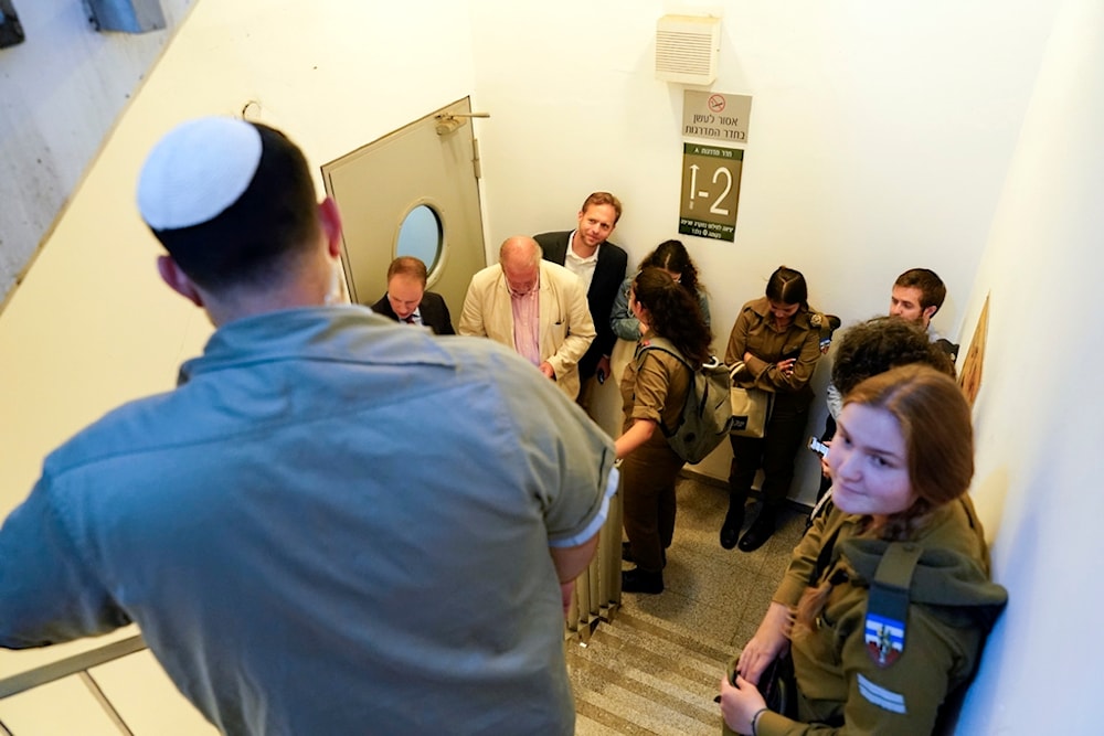 Members of the press pool covering US Secretary of State Antony Blinken take shelter in a stairwell inside the Kirya, which houses the Israeli Security Ministry, October 16, 2023, in 'Tel Aviv', occupied Palestine (AP)