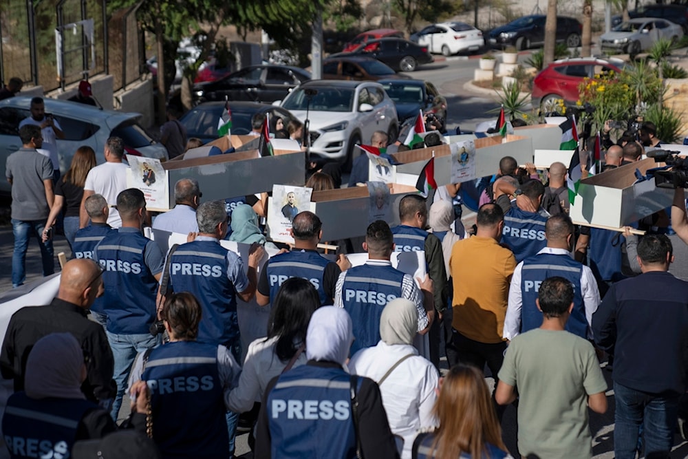 Palestinian journalists carry mock coffins of Palestinian journalists who were killed during the current war in Gaza during a symbolic funeral toward a United Nations office, in the West Bank city of Ramallah, Tuesday, Nov. 7, 2023. (AP)