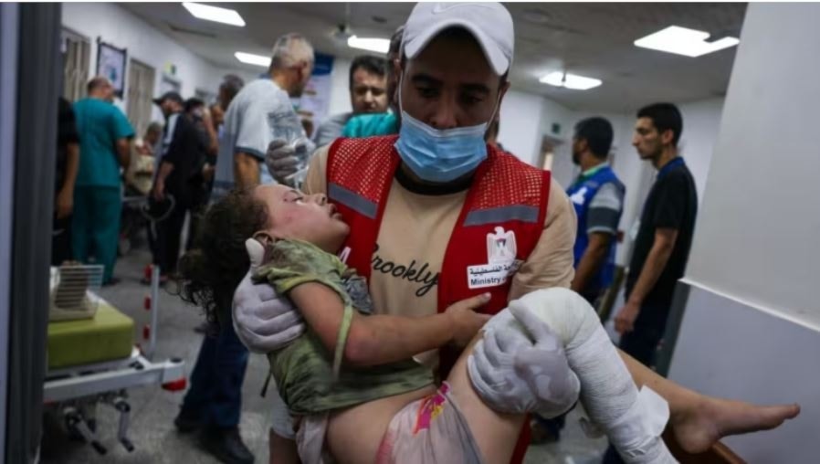An emergency responder carries a wounded child in a hospital following Israeli airstrikes in Rafah, southern Gaza Strip, on October 14. (AFP/Getty Images)