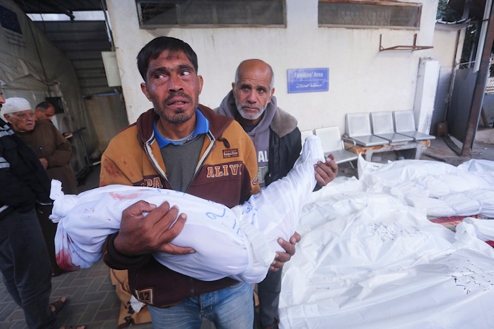 A Palestinian mourns relatives killed in the Israeli bombardment of the Gaza Strip at a morgue in Rafah on Tuesday, Dec. 12, 2023 (AP Photo/Hatem Ali)