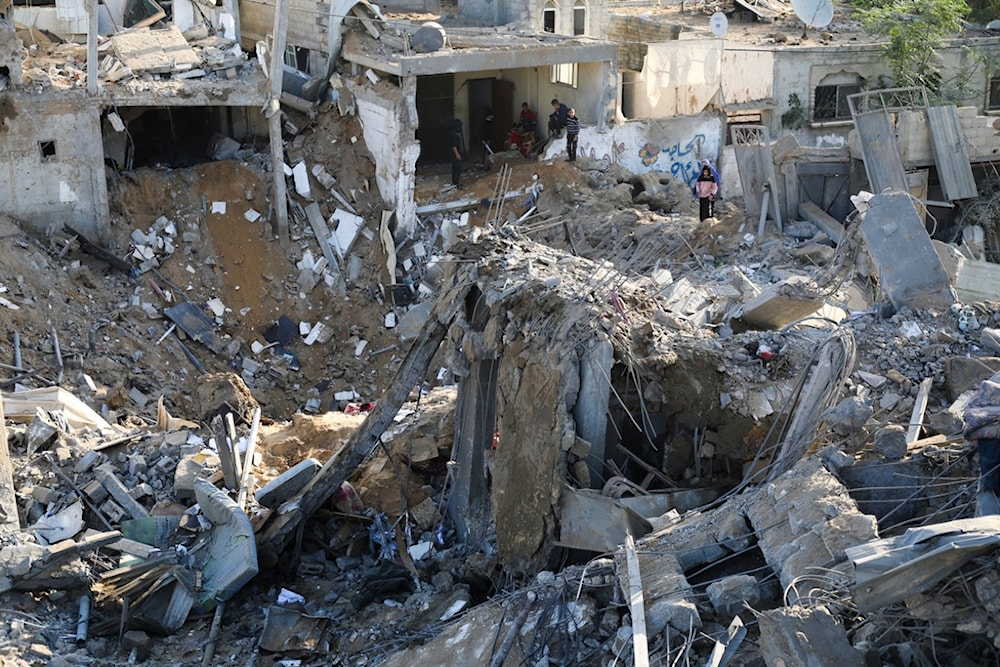 Palestinians look at the destruction by the Israeli bombardment of the Gaza Strip in Rafah, Monday, Dec. 4, 2023 (AP)