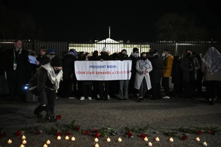A person lays flowers during a demonstration calling for a ceasefire in Gaza in front of the White House in Washington, DC on December 13, 2023 (AFP)