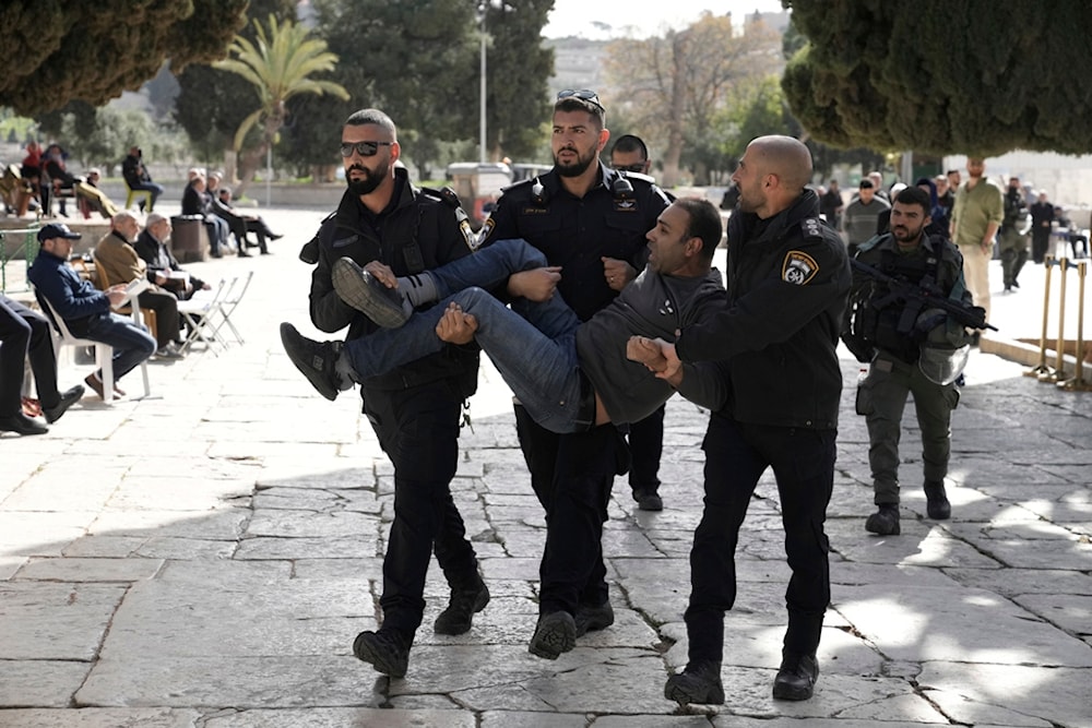 Israeli police detain a Palestinian in the Al-Aqsa Mosque compound following a raid of the site in the Old City of al-Quds during the Muslim holy month of Ramadan, Wednesday, April 5, 2023 (AP)