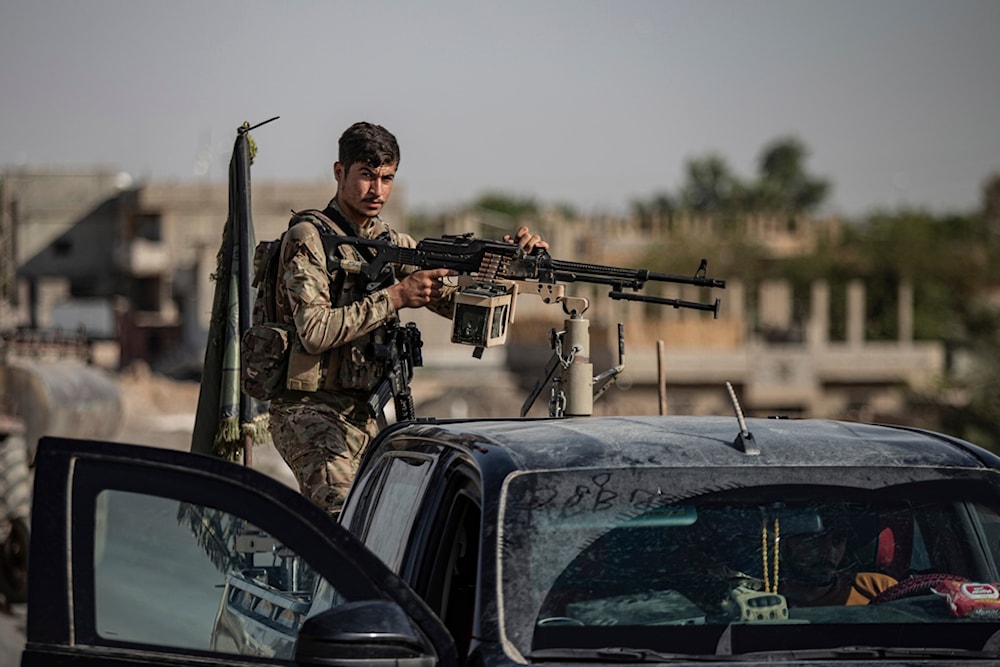 A U.S.-backed Syrian Democratic Forces (SDF) fighter stands on his armored vehicle, at al-Sabha town in the eastern countryside of Deir el-Zour, Syria, Monday, Sept. 4, 2023 (AP Photo/Baderkhan Ahmad)