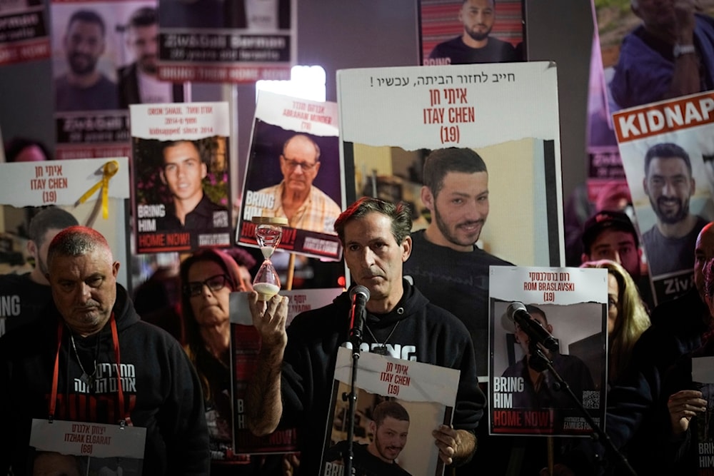 Ruby Chen, center, father of Israeli captive Itay Chen, 19, held by Hamas, holds an hourglass during a rally calling for the return of the captives, in 