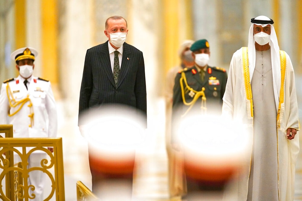 Turkish President Recep Tayyip Erdogan, center left, and Abu Dhabi Crown Prince Sheikh Mohammed bin Zayed Al Nahyan, right, stand for an honor guard at Qasr Al-Watan in Abu Dhabi, United Arab Emirates, Monday, Feb. 14, 2022. (AP)
