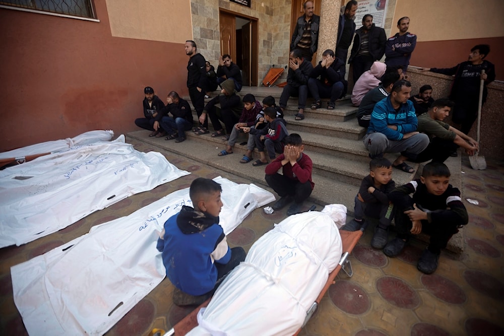 Palestinians mourn relatives killed in the Israeli bombardment of the Gaza Strip outside a morgue in Khan Younis on Friday, Dec. 15, 2023. (AP)