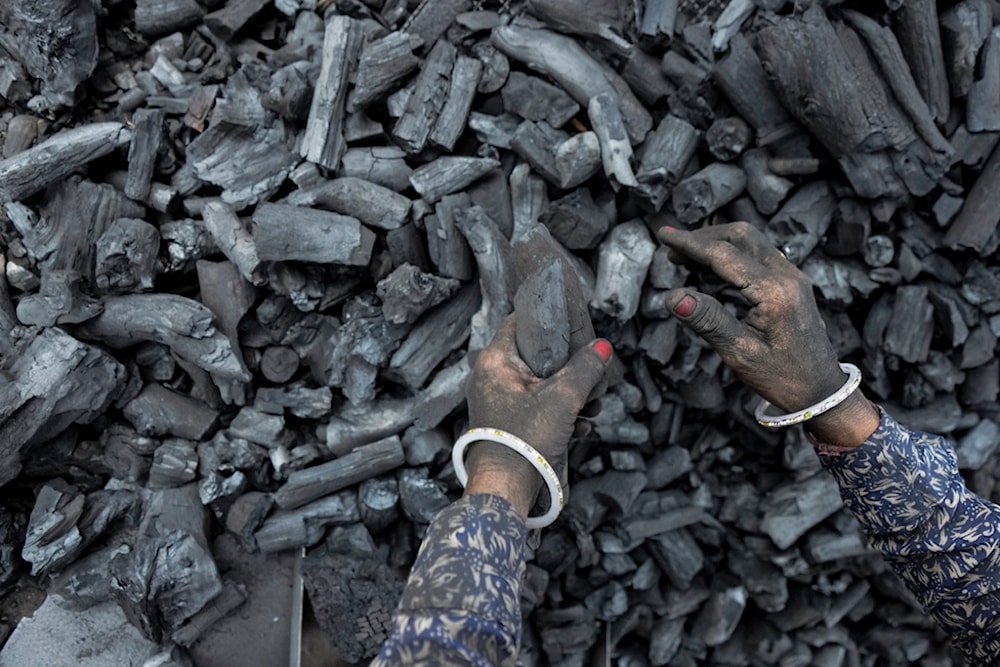 A woman works at a coal depot in Ahmedabad, India, Monday, May 2, 2022. (AP)