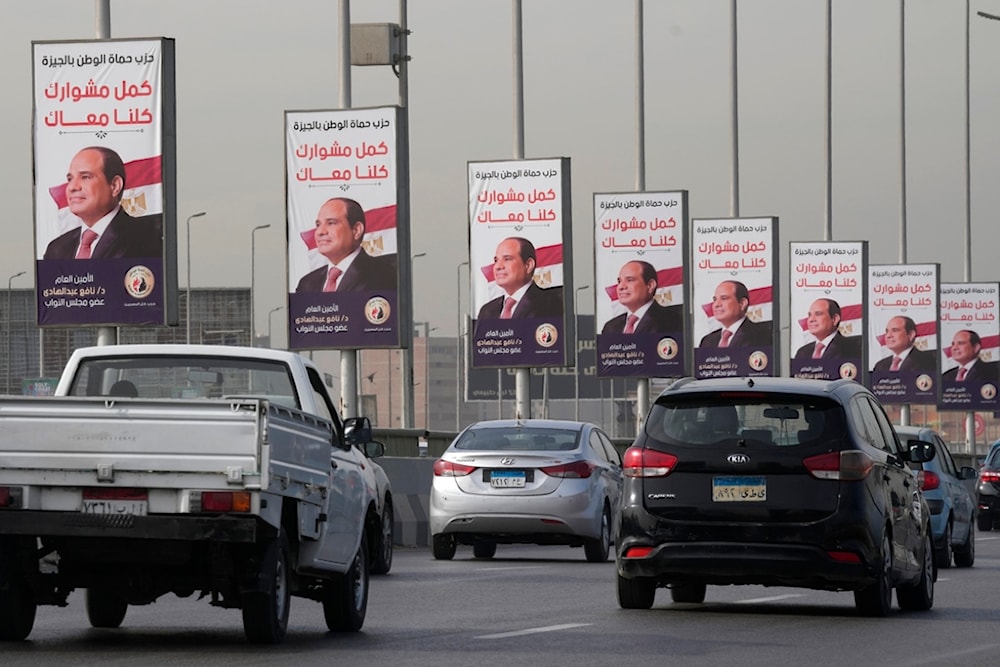 Vehicles pass near banners supporting Egyptian President Abdel Fattah el-Sisi for the presidential elections, in Cairo, Egypt, December 10, 2023 (AP)