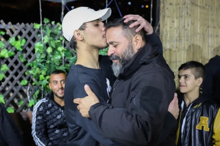 Palestinian child Mohammad Al-Awar left kisses his father’s forehead after being freed by Hamas on November 26. (AFP)