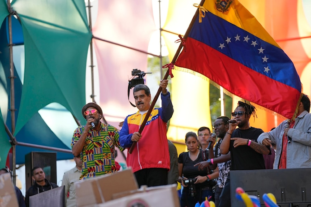 Venezuela's President Nicolas Maduro waves a Venezuelan flag after his speech during the closing campaign on Venezuela Referendum on dispute territory with Guyana in Caracas, Venezuela, Friday, Dec. 1, 2023. (AP)