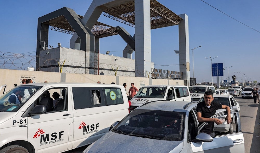 Vehicles wait outside the gate of the Rafah border crossing with Egypt in the southern Gaza Strip on November 1, 2023 (AFP)