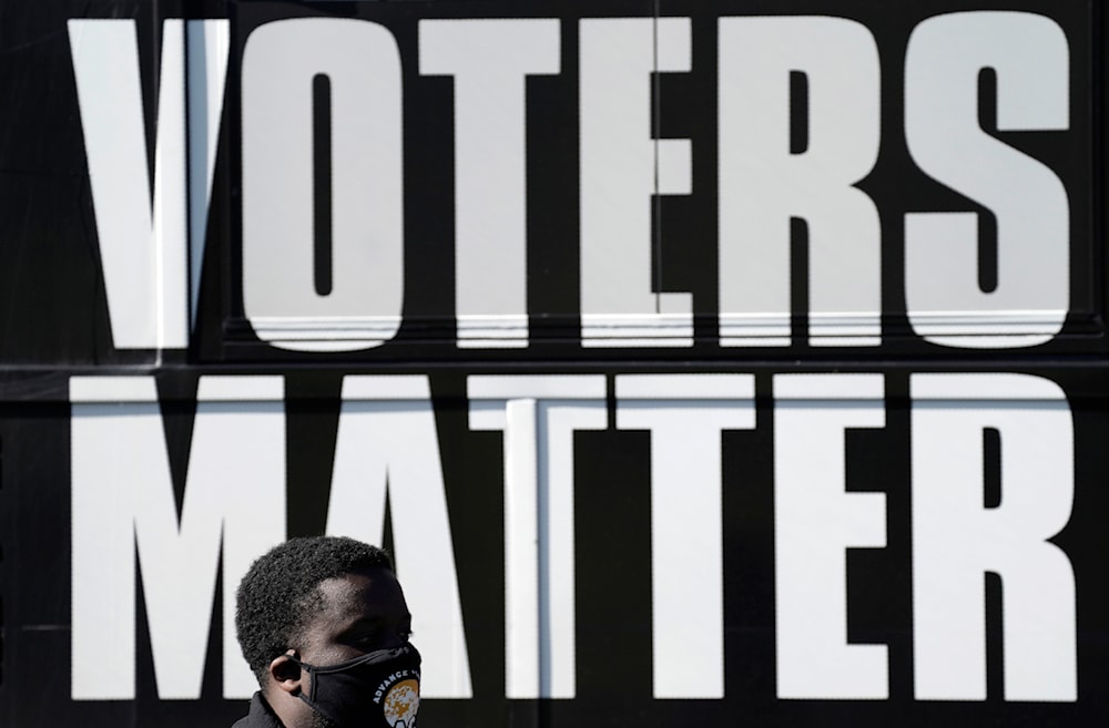 A man wearing a mask gathers with a group in support of Black Voters Matter at the Graham Civic Center polling site in Graham, N.C., Nov. 3, 2020. (AP)
