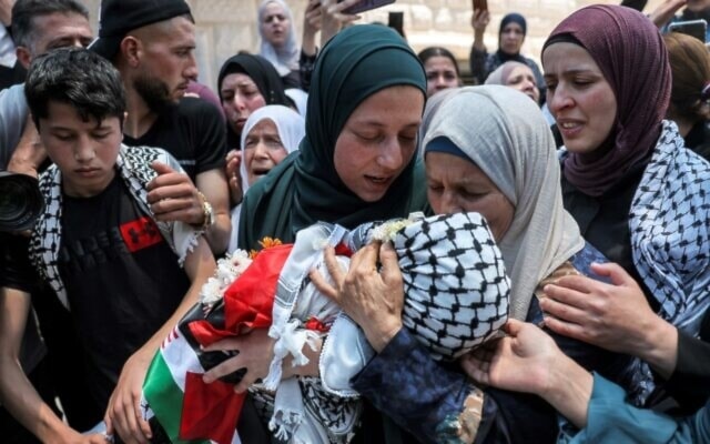 The mother (C) of Mohammed Haitham al-Tamimi, a 2.5-year-old Palestinian child shot by the IOF a week earlier, carries his body during his funeral in the village of Nabi Saleh, June 6, 2023. (AFP)