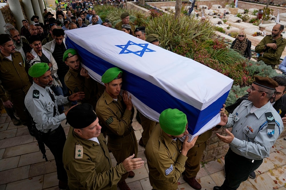 Israeli soldiers carry the flagged covered coffin of a sergeant as family and friends follow during his funeral in occupied Palestine,Thursday, Dec. 21, 2023.