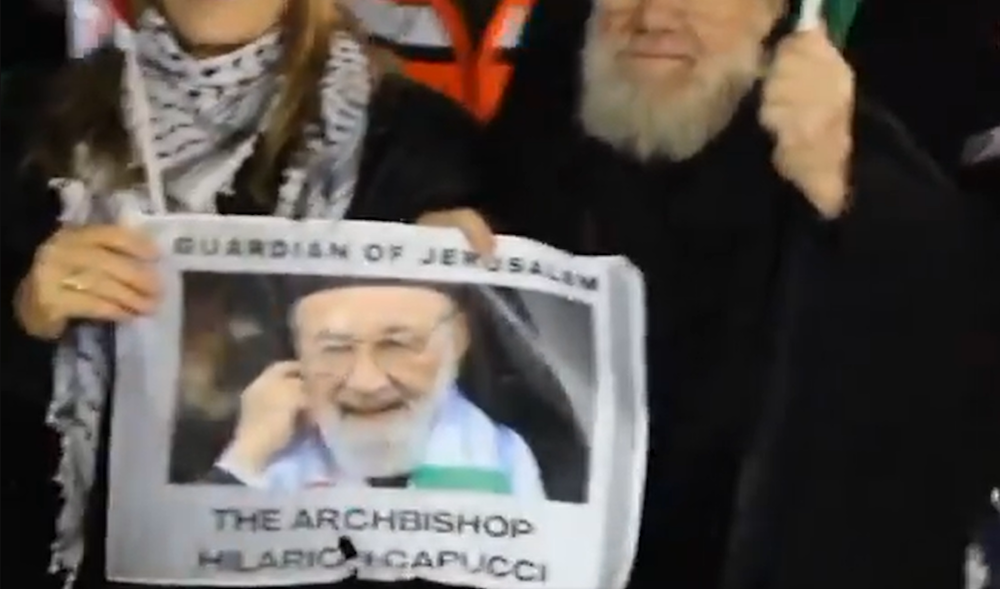 A screenshot from a video showing Archimandrite Abdullah Yulio, parish priest of the Melkite Greek Catholic church in Ramallah, stands with Palestinian protesters on December 23, 2023. (Quds News Network)