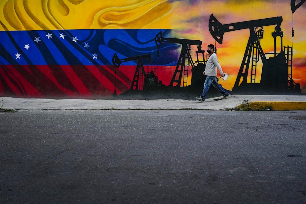 A man walks past a mural featuring oil pumps and wells in Caracas, Venezuela, Saturday, May 21, 2022. (AP)