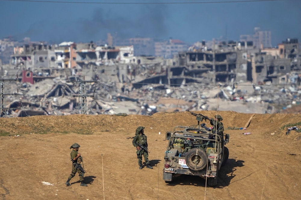 Israeli occupation forces troops are seen near the Gaza Strip border, in southern occupied Palestine, December 24, 2023 (AP)