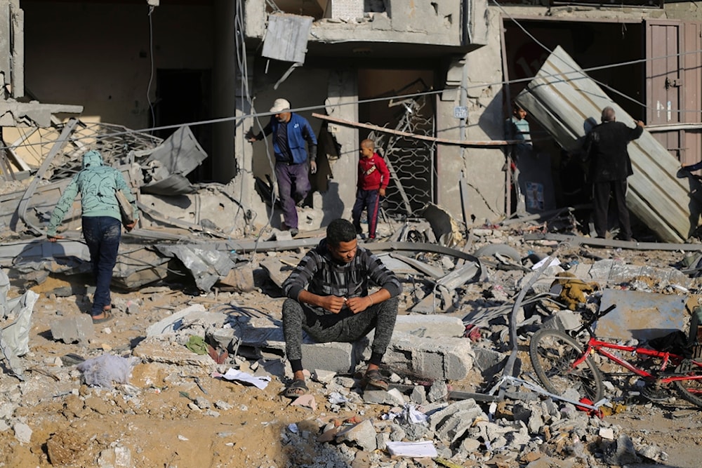Palestinians look at the destruction by the Israeli bombardment of the Gaza Strip in Rafah, December 4, 2023 (AP)