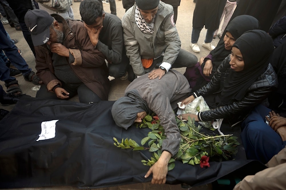 Palestinians mourn relatives killed in the Israeli bombardment of the Gaza Strip outside a morgue in Khan Younis on Sunday, Dec. 24, 2023 (AP Photo/Mohammed Dahman)