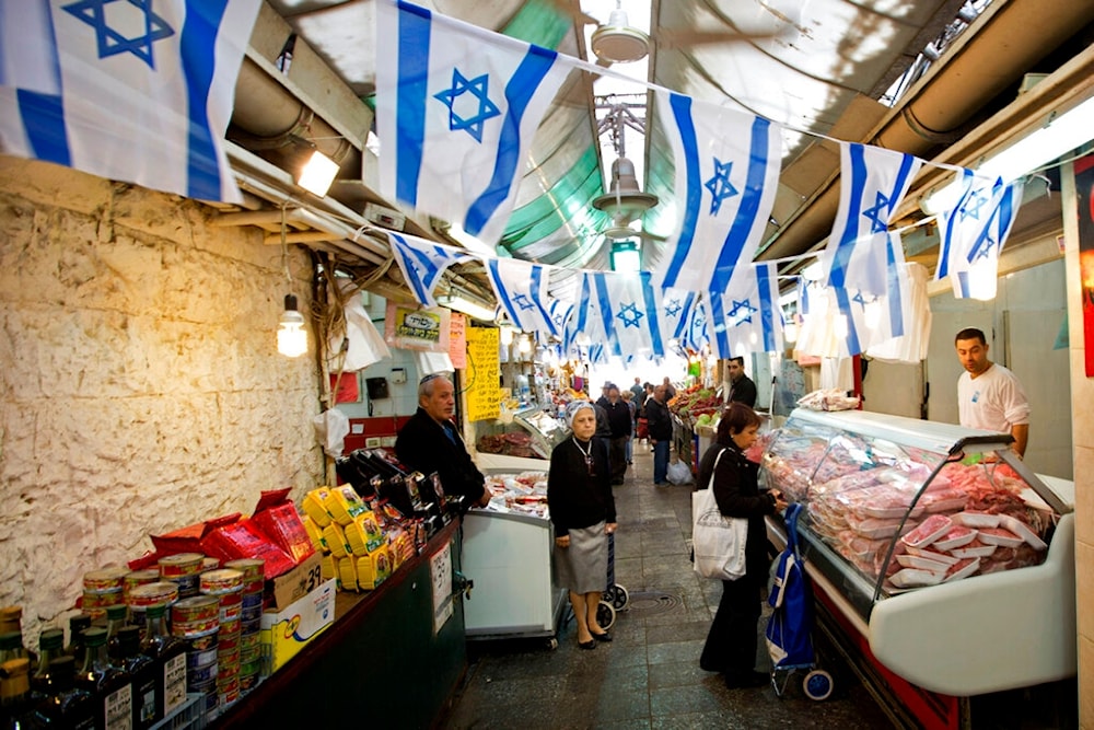 Israeli settlers stand in the market, Occupied Al-Quds, Wednesday, April 22, 2015 (AP)
