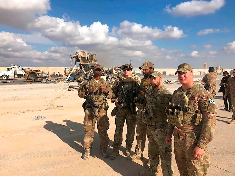 US Soldiers stand at a site of Iranian bombing at Ain al-Asad air base in Anbar, Iraq, January 13, 2020 (AP)