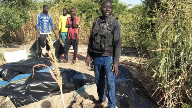 A man stands next to body bags of farmers that were victims of an attack, in the Zabarmari district, near Maiduguri, on November 6, 2023. (AFP)