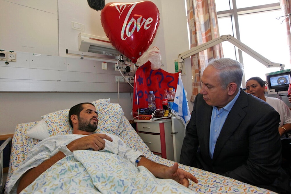 Israel's Prime Minister Benjamin Netanyahu, right, visits a man injured in an attack at the border with Egypt, Friday, Aug. 19, 2011 (AP)