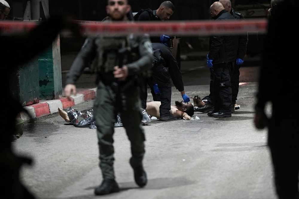 Israeli security forces examine the body of the Palestinian martyr at the scene of a stabbing operation at the 