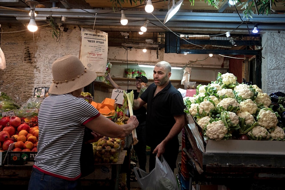 A woman shops for vegetables in the Mahane Yehuda Market in occupied al-Quds, occupied Palestine on Sunday, September 25, 2022 (AP)