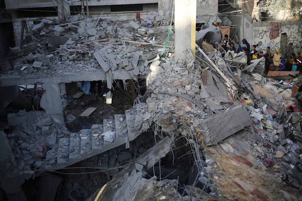 Palestinians look at the destruction after an Israeli strike in Rafah, Gaza Strip, December 24, 2023 (AP)