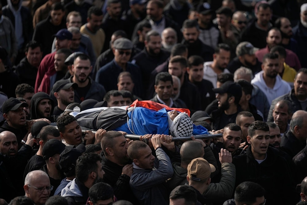 Palestinians carry the body of one that was killed after an Israeli military raid on Nur Shams refugee camp in the West Bank, Wednesday, Dec. 27, 2023 (AP)