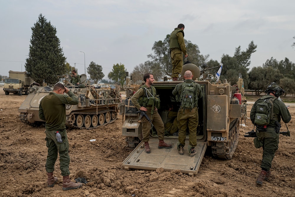 Israeli occupation forces are seen at a staging area near the Gaza wall, in southern occupied Palestine, December 28, 2023 (AP)