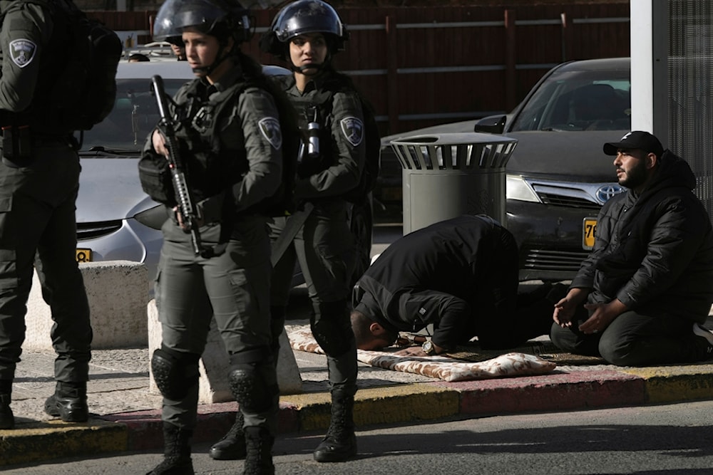 Palestinian worshipers who were prevented from entering the al-Aqsa Mosque, pray outside al-Quds' Old City as Israeli occupation forces stand guard on Friday Dec. 22, 2023. (AP)