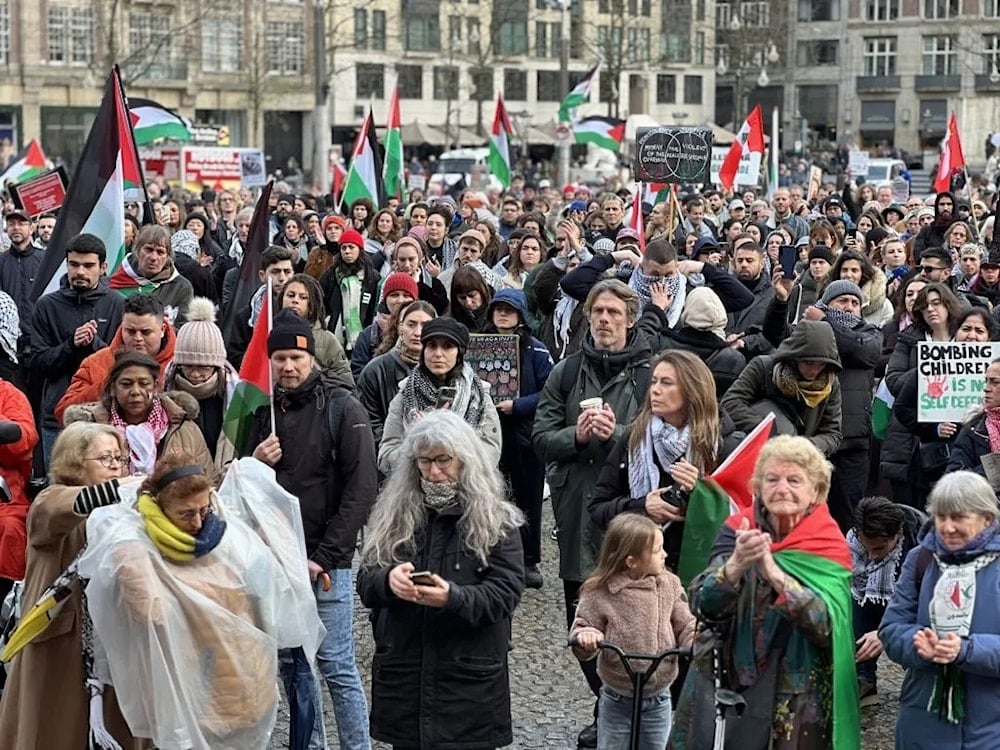 Demonstrators with banners gather at Dam Square and march to Museumplein (Museum Square) to call for a permanent ceasefire in Gaza during a rainy day in Amsterdam, Netherlands on November 26, 2023. (AFP)