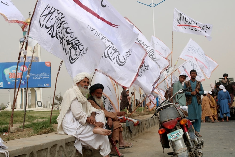 Afghan elderly men sit near to the Taliban flags during a celebration marking the second anniversary of the withdrawal of U.S.-led troops from Afghanistan, Kandahar, Afghanistan, Aug. 15, 2023. (AP)