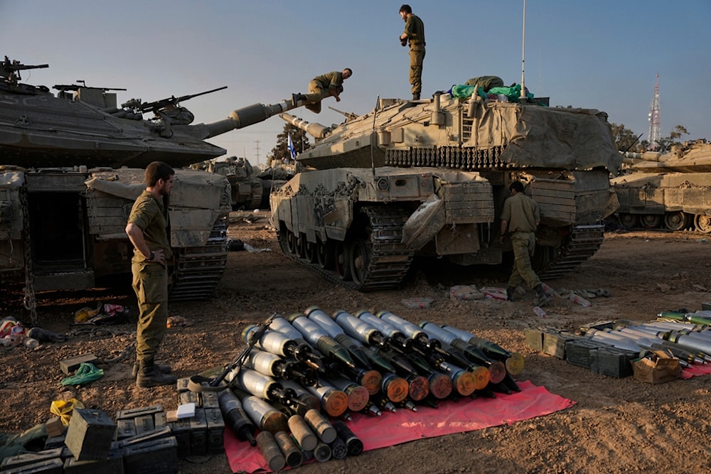 Israeli soldiers load shells onto a tank at a staging area in southern Palestine near the border with Gaza on Sunday, Dec. 31, 2023. (AP)
