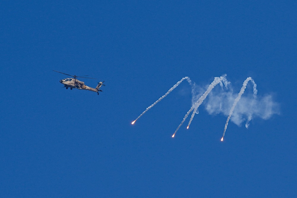 An Israeli military helicopter releases flares over the Israel-Gaza border on Monday, Dec. 4, 2023. (AP)