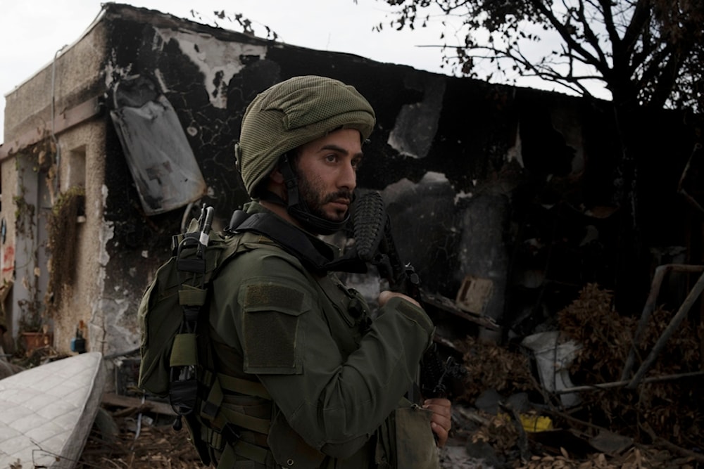 An Israeli soldier stands guard during near the Gaza separation wall on November 12, 2023 (AP)