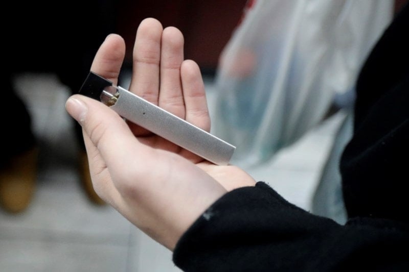 A man displays his Juul electronic cigarette while shopping at a convenience store in Hoboken, NJ, December 20, 2018 (AP)