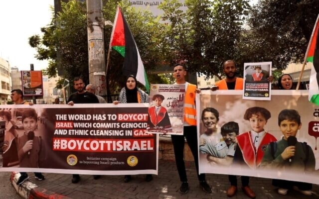 Palestinians holds posters asking for the boycotting of Israeli products during a rally in the occupied West Bank city on October 28, 2023. (AFP)