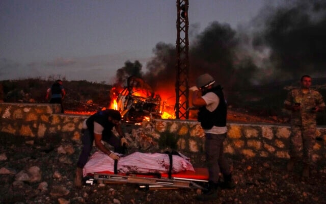 Civil Defense workers remove the body of Reuters videographer Issam Abdallah who was killed by an Israeli shelling, at Alma al-Shaab, south Lebanon, Friday, October 13, 2023. (AP)