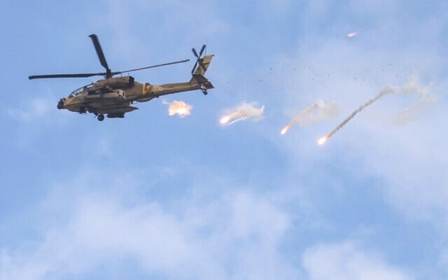 An Israeli Air Force AH-64 Apache attack helicopter releases flares during a raid in Jenin in the occupied West Bank on June 19, 2023. (AFP)