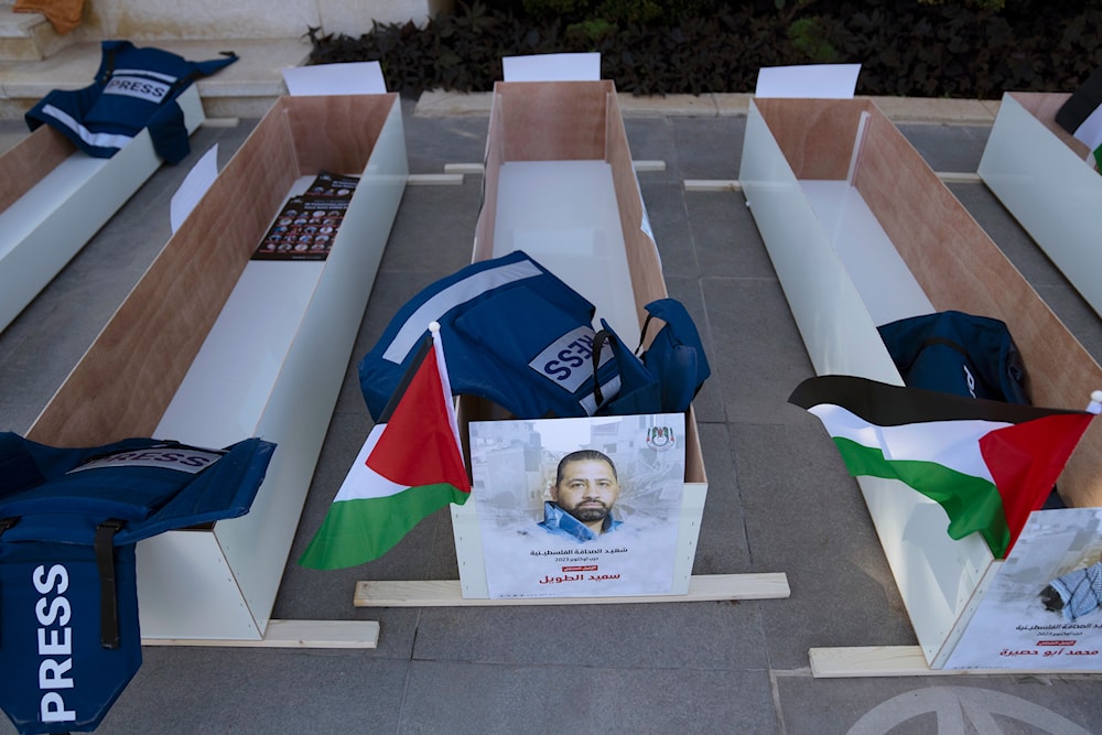 A poster with name and picture of Saed Taweel is posted on mock coffins in the West Bank city of Ramallah, Tuesday, Nov. 7, 2023. (AP)