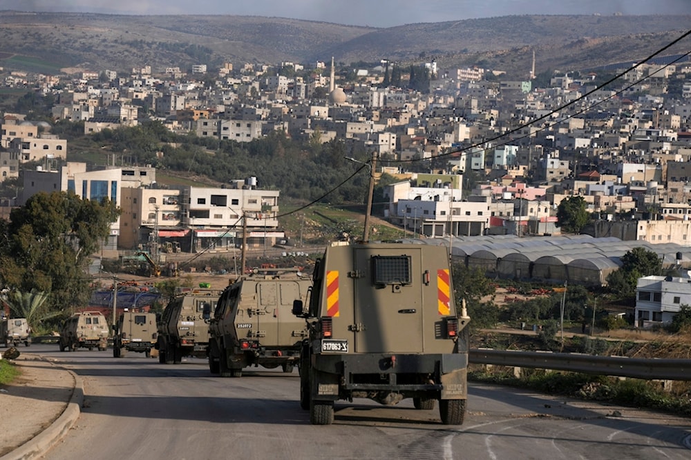 A convoy of Israeli army vehicles is seen during a military raid into Faraa refugee camp, West Bank, Friday, Dec. 8, 2023. (AP)